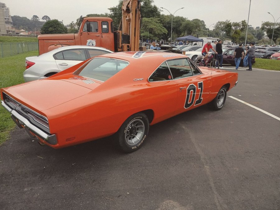 Dodge Charger laranja de traseira, em encontro de antigos